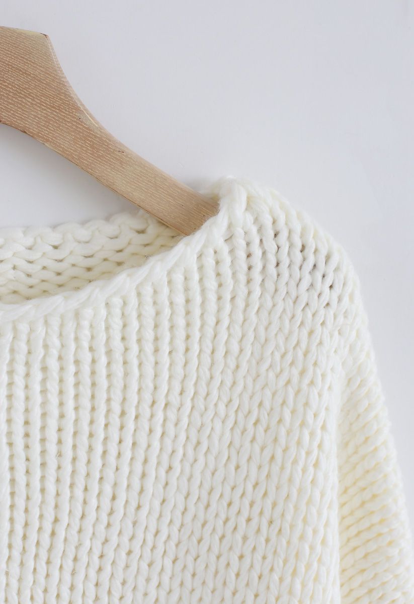 L'autre côté du gros pull tricoté à la main en blanc